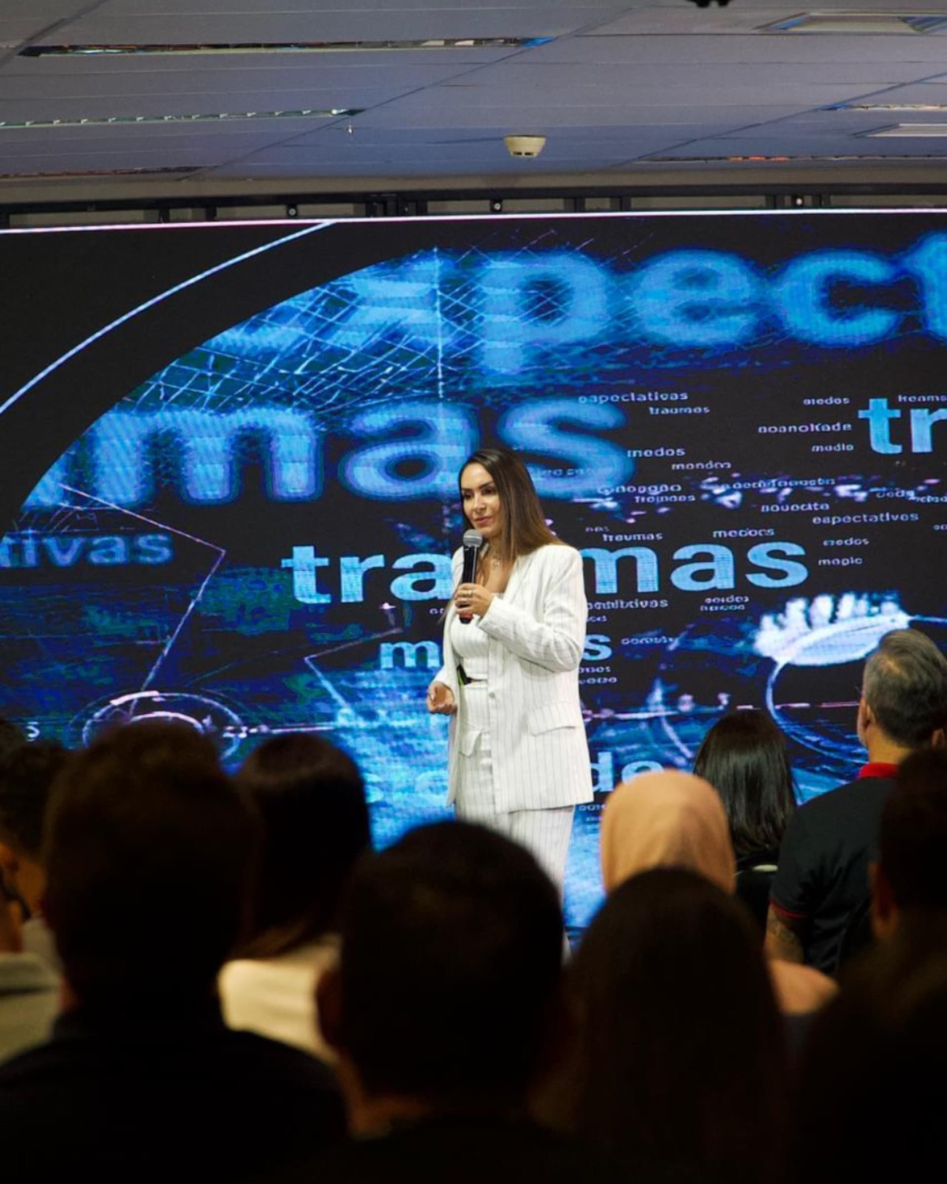 Mônica Souza apresentando com telão ao fundo
